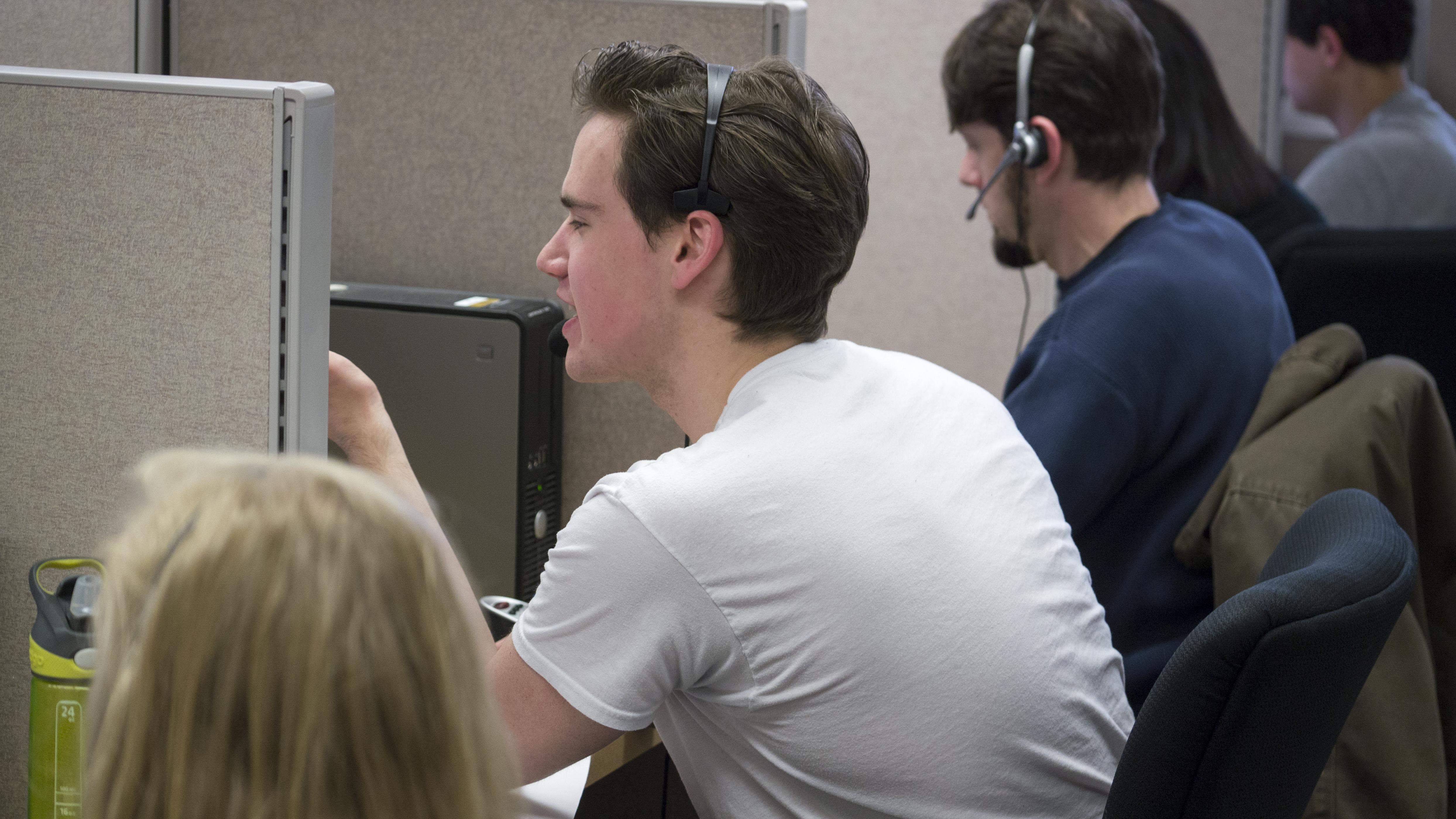Students in the ISRC call center wearing headsets and talking on phones
