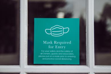 Sign in business window stating mask requirement